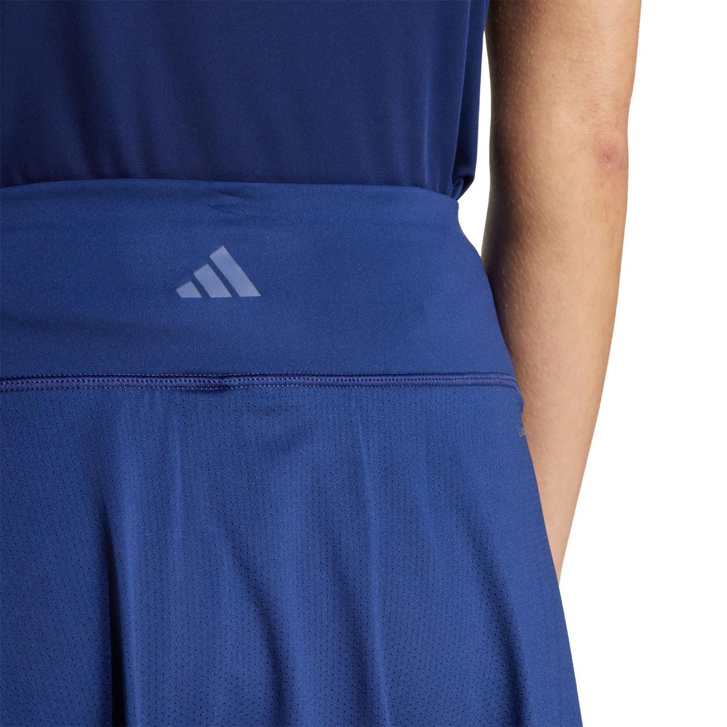 Rear view of the ADIDAS Womens Club Tennis Skirt - Navy. The waistband features a small adidas logo, showing the brand’s commitment to recycled materials. Made with Climacool technology, it looks lightweight and breathable, ideal for active wear.