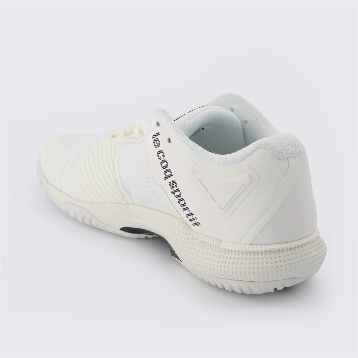 The Le Coq Sportif Futur LCS T01 All Court Tennis Shoes in white are showcased against a white background. These sneakers boast a textured design with a breathable mesh upper and the brand's name printed on the side in black lettering. They feature a Comfort EVA sole with a ribbed pattern for enhanced grip.