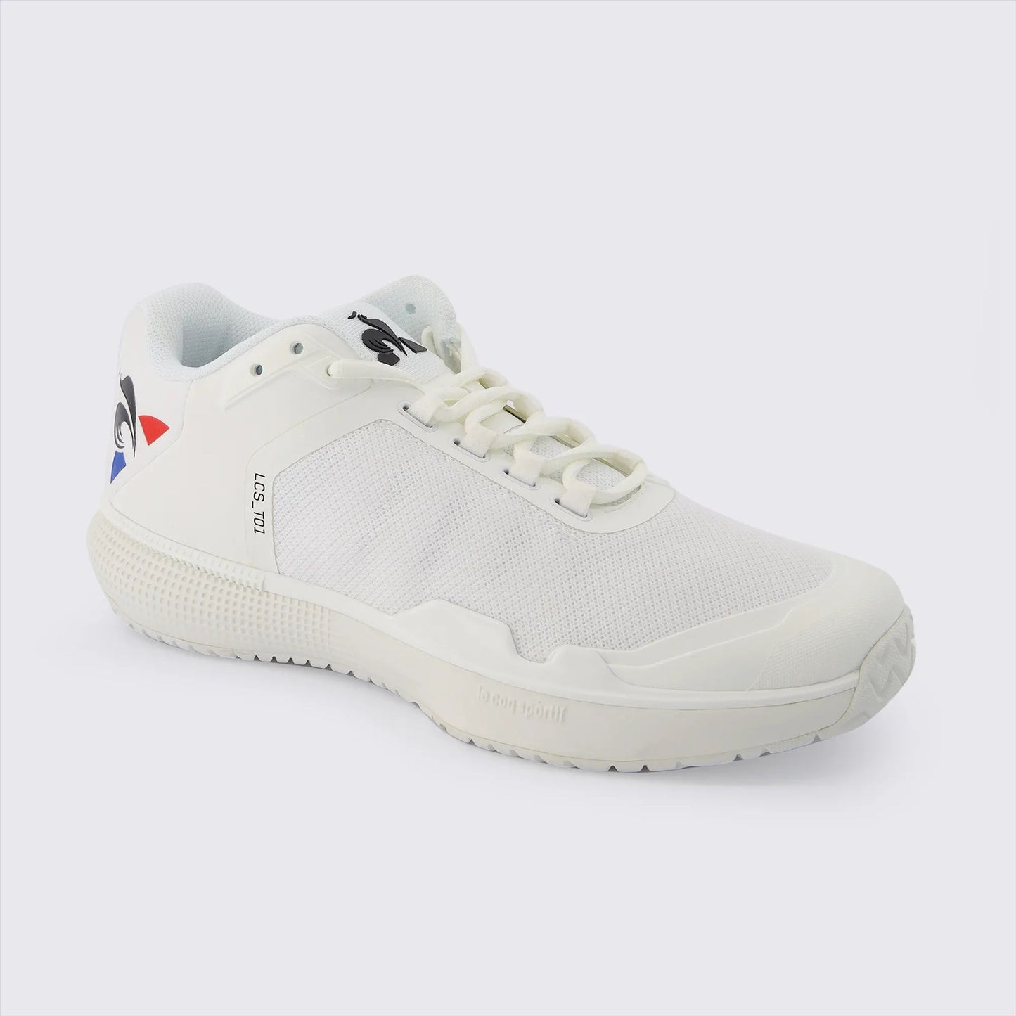 Introducing the Le Coq Sportif Futur LCS T01 All Court Tennis Shoes in white, from the renowned brand Le Coq Sportif. These tennis shoes feature a breathable mesh upper that enhances their sleek and contemporary design on a pristine white canvas. They come with a textured sole for added grip, Comfort EVA technology for superior cushioning, and a classic lace-up style. The shoe showcases a distinctive logo with black imagery alongside striking blue and red accents on the heel.