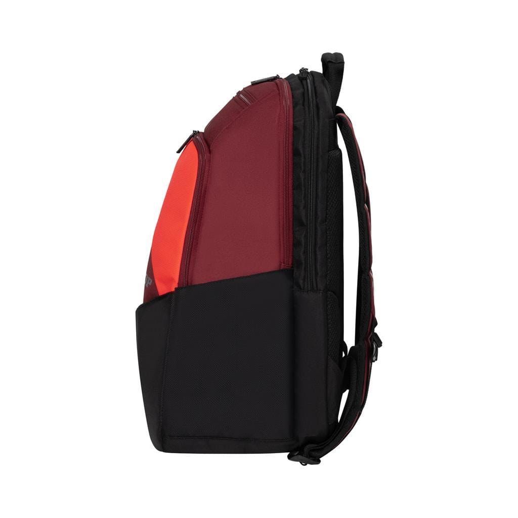 A sleek, modern tennis backpack from Dunlop, the CX Performance Tennis Backpack in a striking black and red color scheme, is shown from the side. The upper section is red while the lower section is black. It features a streamlined silhouette with adjustable shoulder straps for effortless racket carrying.