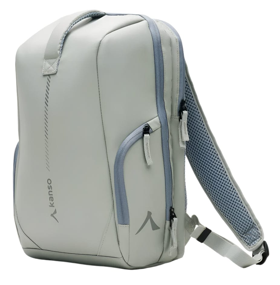 The Kanso Intuko Tennis 23L Backpack in grey offers a sleek, modern design with two zippered front pockets, an adjustable shoulder strap with mesh pad, and a top carry handle. Featuring reflective print and "kanso" on the side, it combines functionality and style for any occasion.