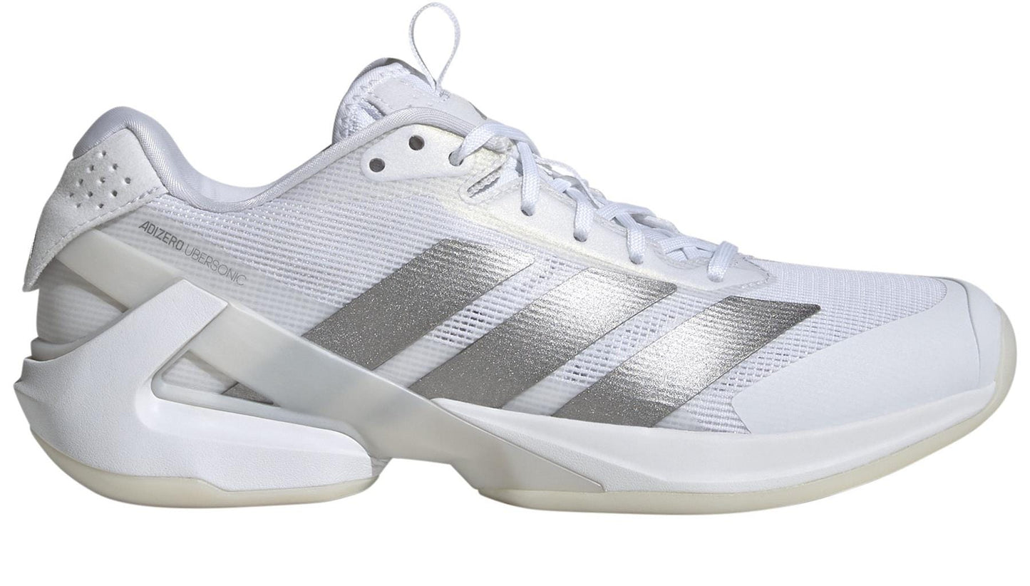 With a sleek design, these ADIDAS Adizero Ubersonic 5 women's tennis shoes in white feature three metallic stripes, a unique heel structure, and a lightweight mesh upper with matching white laces. "Adizero Ubersonic" text accents the side.