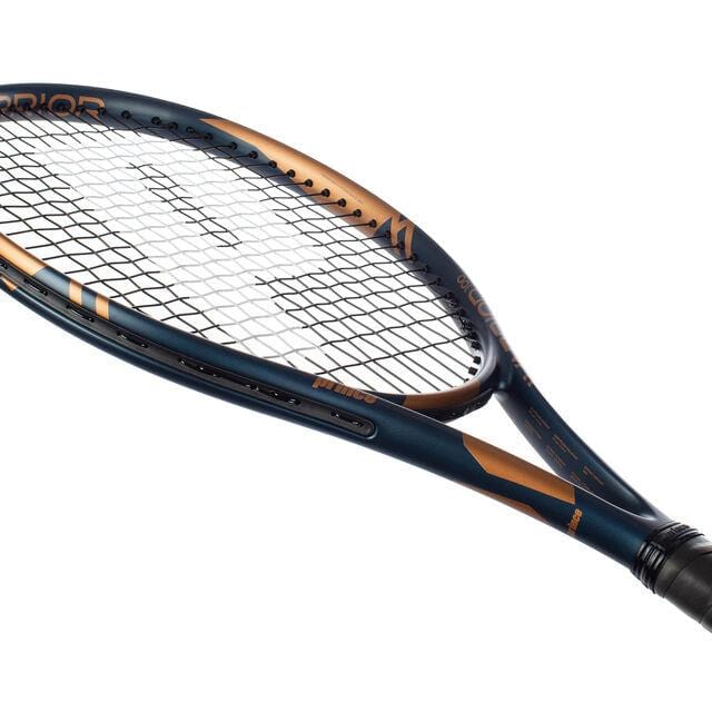 The Prince Warrior 100 2023 265g Tennis Racket, crafted from graphite, features a bold blue and gold design with a unique black grip. The stringed head prominently displays the Prince logo on the frame at a slight angle in the image.