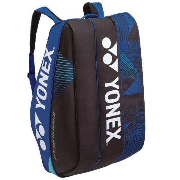 The Yonex 924212EX Pro 12 Racket Tennis Bag in cobalt blue and black prominently displays the Yonex logo and name in white. Featuring a modern, sleek design, this bag includes adjustable shoulder straps, a zipper closure, and dedicated compartments for your rackets.