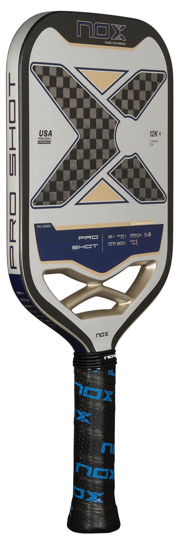 The NOX Pro Shot Pickleball Paddle - Black / Blue by NOX features a 12K carbon fibre surface, checkered black and gray center with a large "X" logo, black grip with blue "NOX" text, and printed technical specs.
