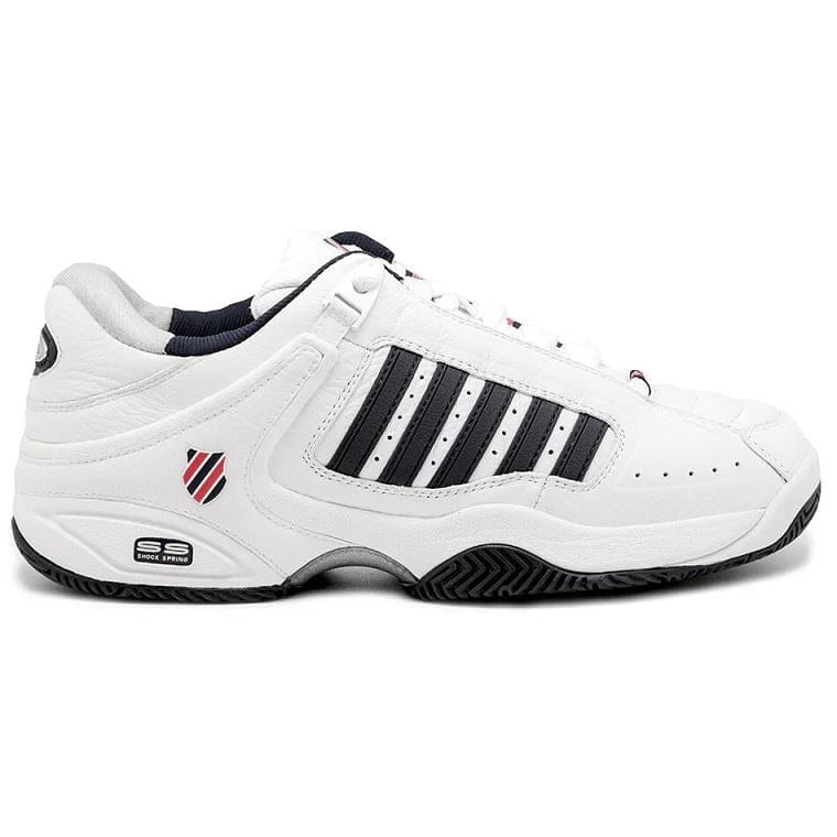 The K-Swiss Defier RS Men's Tennis Shoes in White, Dress Blue, and Fiery Red feature a white athletic design with dress blue stripes on the sides, durable dress blue detailing around the sole, and a small fiery red and dress blue shield logo near the heel. These shoes provide stability with their low-top design and have a rubber sole featuring a textured pattern.