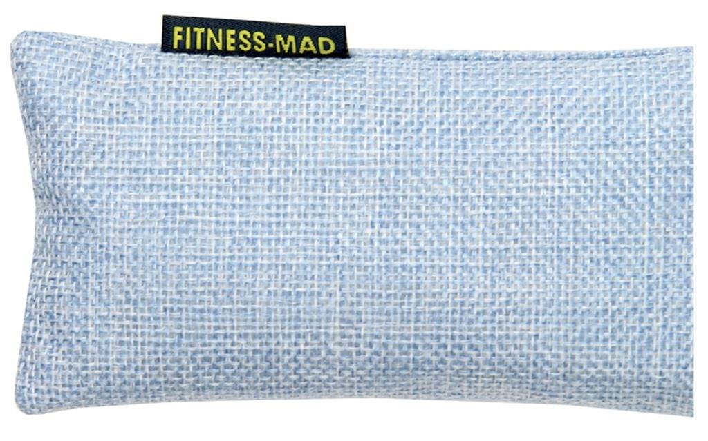 A rectangular eye pillow in blue, crafted with a textured fabric surface and featuring active charcoal deodorizers. It includes a small black tag with yellow text reading "FITNESS-MAD.