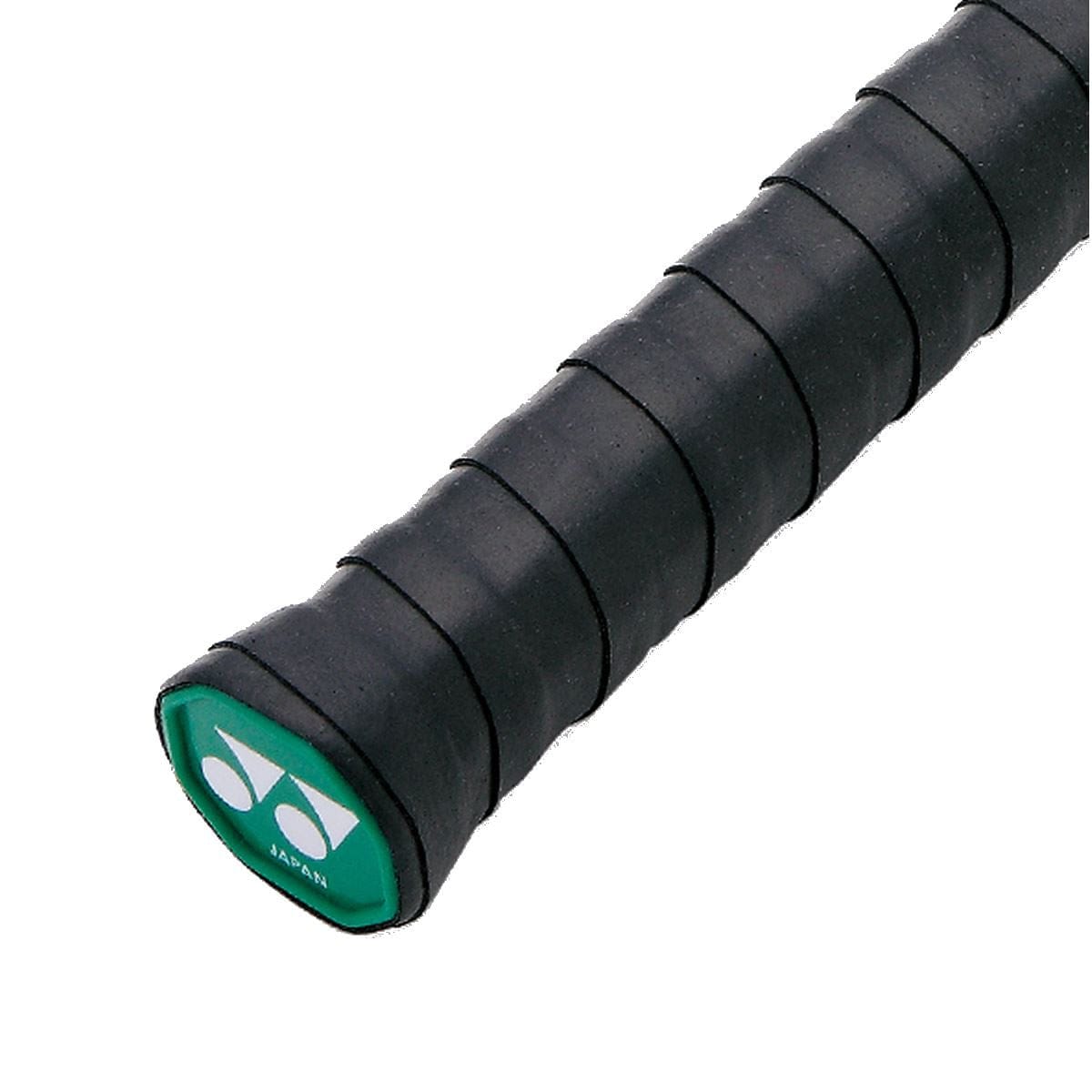 Close-up of a black badminton racket handle wrapped with a Yonex AC102EX Super Grap Tennis Overgrip in black. The end cap is visible, featuring a green background and white logo, providing enhanced sweat absorption for optimal play.