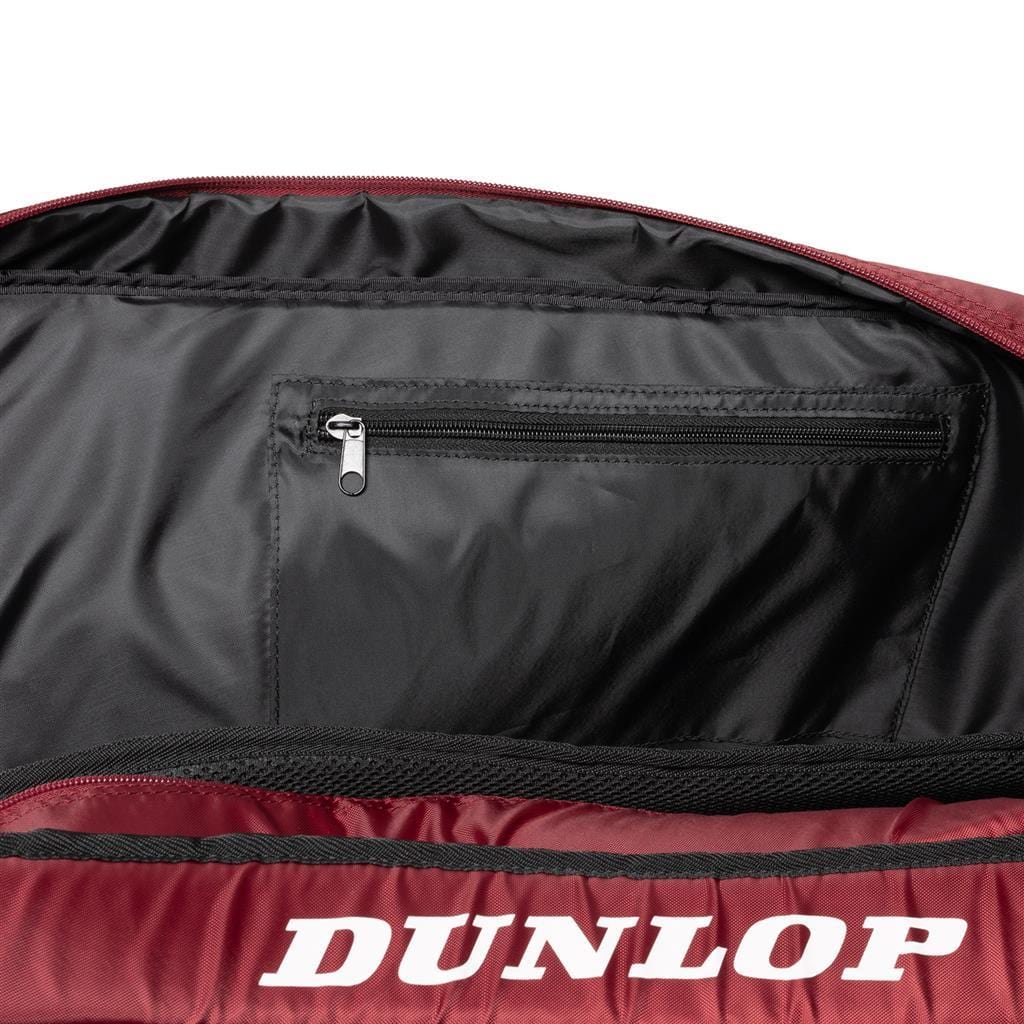 A close-up of an open Dunlop-branded bag reveals a small zippered pocket inside. The black and red exterior combined with its spacious design makes the Dunlop CX Club 10 Tennis Racket Bag both stylish and functional, ideal for any athlete's gear.