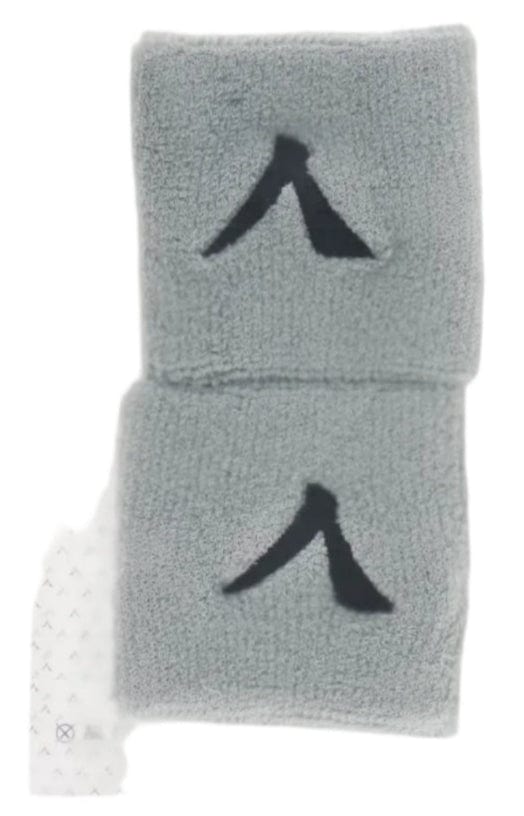 The Kanso 7cm Wristband - 2 Pack - Grey features absorbent fabric for comfort. The minimalist black design is visible through its transparent plastic packaging, showcasing two gray wristbands against a clean white background.