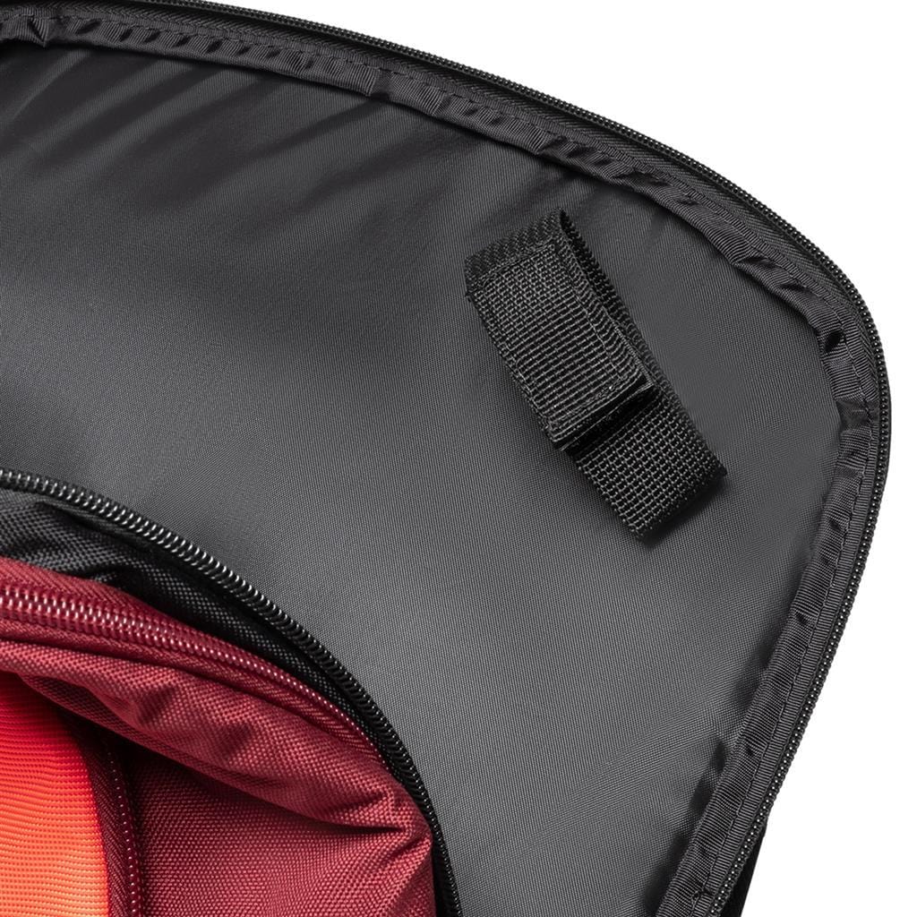 A detailed view of the Dunlop CX Performance Tennis Backpack in black and red, featuring an open design with a velcro strap on the flap. The interior reveals a striking red lining and a pocket, while the partially unzipped backpack showcases the fabric details and construction, ideal for carrying tennis rackets.