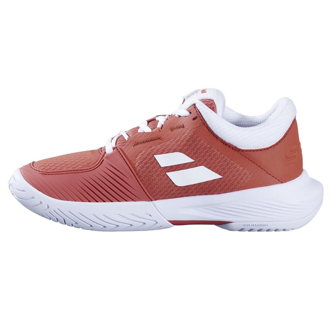 The Babolat SFX 4 Women's Tennis Shoe in Terra Cotta showcases a low-cut modern design with white accents, two stripes, white laces, and sole—blending comfort and style.