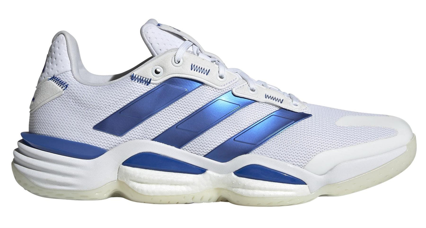 The ADIDAS Stabil 16 Mens Indoor Court Shoes in white and blue feature a mesh upper, textured sole, blue stripes, and accents. They include the signature BOOST midsole for comfort along with white laces and a sleek design.