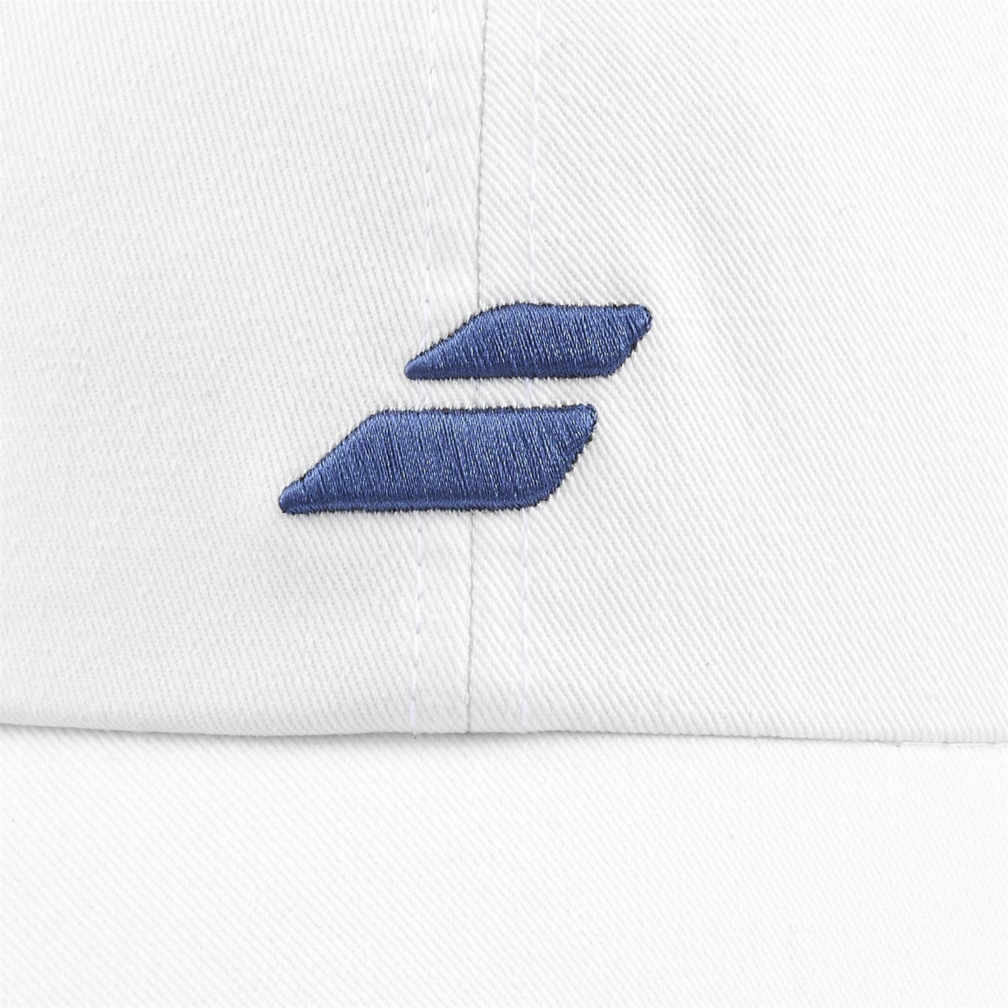 Close-up of the Babolat Pure Drive Cotton Cap in white, made from recycled cotton. It features an embroidered design with two overlapping blue chevrons and a sleek metal buckle, all highlighted by the plain background.