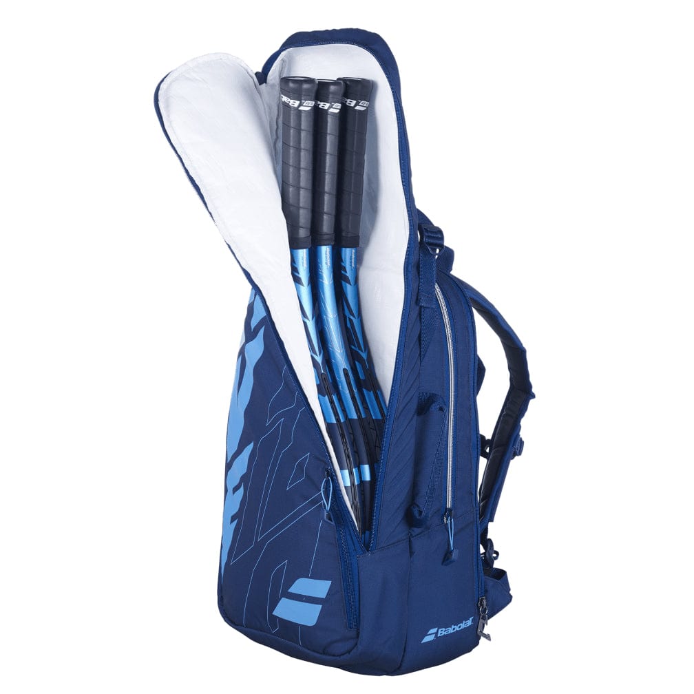 A Babolat Pure Drive Tennis Backpack - Blue, by Babolat, partially open to display three blue and black tennis rackets. This bag includes an isothermal insulated compartment for your tennis essentials, along with visible zippers and branding.