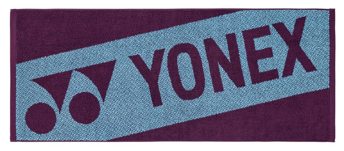 The Yonex AC1113EX Tennis Sports Towel - Bordeaux is a 100% cotton rectangular towel with a Bordeaux background, featuring the Yonex logo and name diagonally—ideal for your sports sessions.