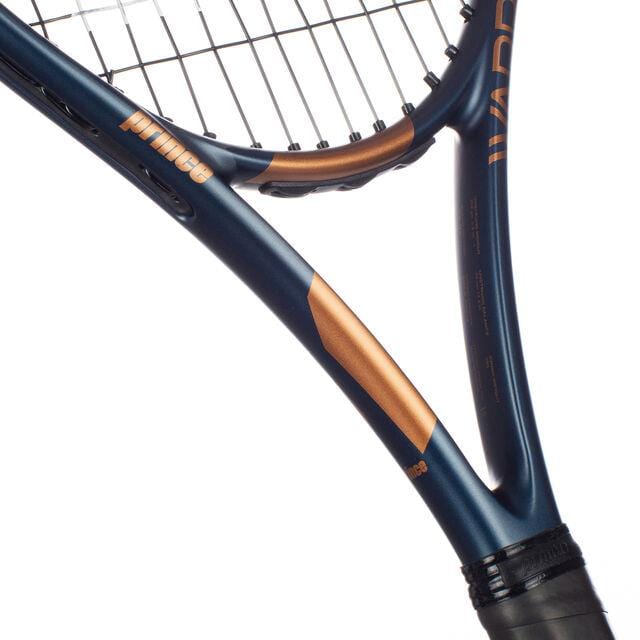 A close-up of the Prince Warrior 100 2023 265g Tennis Racket reveals a captivating blue and copper color scheme. The "Prince" logo is prominently adorned on the graphite frame. The focus remains sharp on the junction of the strings and frame, accentuating its detailed design.