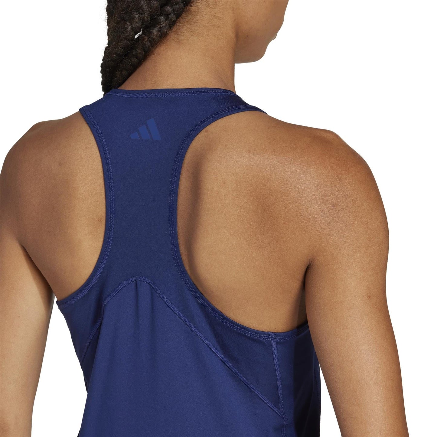 A person with braided hair is wearing a navy ADIDAS Women's Club Tennis Tank Top by adidas, featuring a small logo on the upper back. They are facing away, highlighting their shoulders and upper back in this breathable recycled Climacool design.