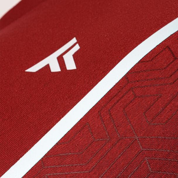 Close-up of the cardinal red cotton fleece fabric, featuring a geometric logo in white on the upper left and subtle patterned lines, reminiscent of the high-performance design seen in the Tecnifibre Mens Team Tennis Sweater by Tecnifibre.