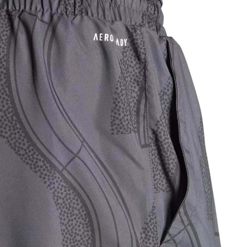 Close-up of carbon and black ADIDAS Club Graphic Mens Tennis Shorts by adidas, showcasing a patterned design with an open pocket. Made from 100% recycled materials, the word "AEROREADY" is printed near the waistband.