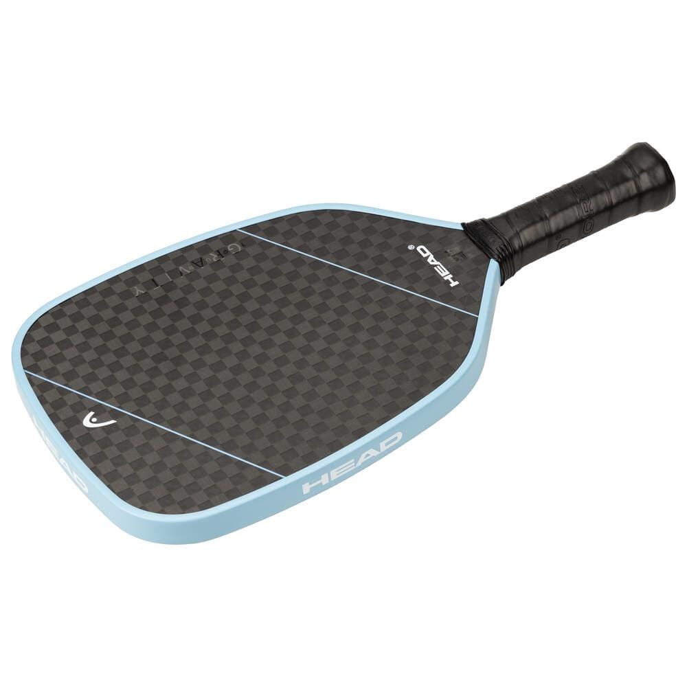 The HEAD Gravity Tour 2025 Pickleball Paddle in Carbon Black/Blue features a black and gray checkered 12K carbon surface, light blue edge, black grip handle, and the "HEAD" logo printed on the side.