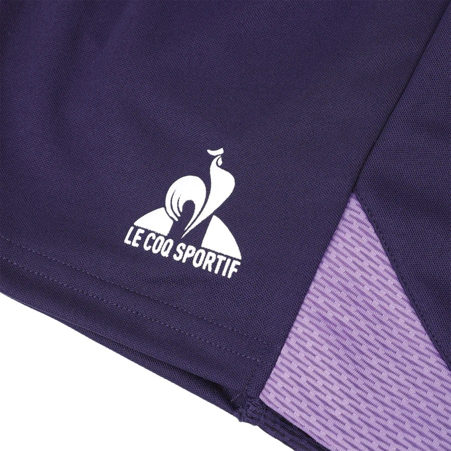 The Le Coq Sportif Pro Mens Tennis Shorts in Purple Velvet showcase a close-up of the fabric with the brand's white logo. The design includes a stylized rooster above the brand name, and a lighter purple textured panel enhances optimal movement, making these shorts ideal for performance.