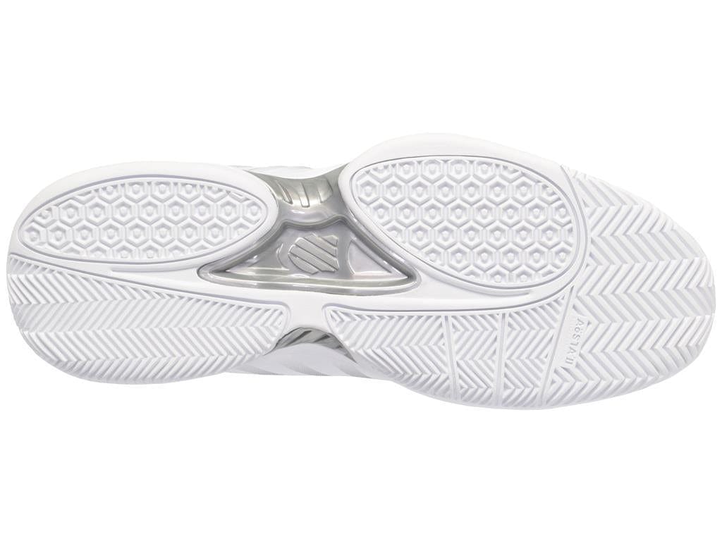 The image features the sole of the K-Swiss Receiver V Men's Tennis Shoes in White, Peacoat, and Silver, displaying textured hexagonal patterns and herringbone designs to boost performance. A central section with a metallic look and diverse grooves provides cushioning and optimal traction.