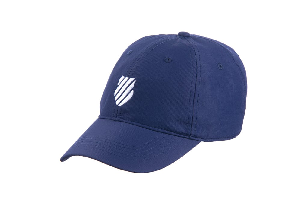 The K-Swiss Men's Tennis Cap in navy/white showcases a stylish white shield emblem on the front. With its curved bill and visible stitching details, this cap not only protects against the sun but also provides a fashionable touch, making it ideal for sunny days.