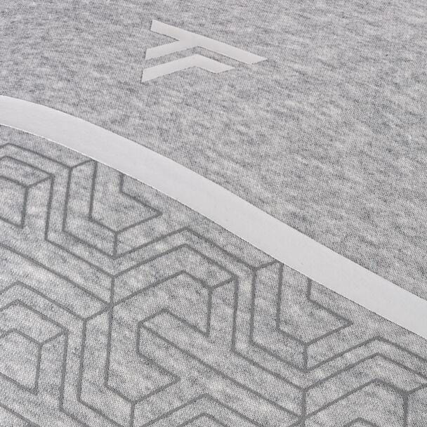 Close-up of silver fabric showcasing a geometric pattern, made from high-performance cotton fleece. The design features interlocking shapes beneath a light diagonal band. A subtle logo with two overlapping arrows is positioned above the pattern, reminiscent of the Tecnifibre Mens Team Tennis Sweater by Tecnifibre.