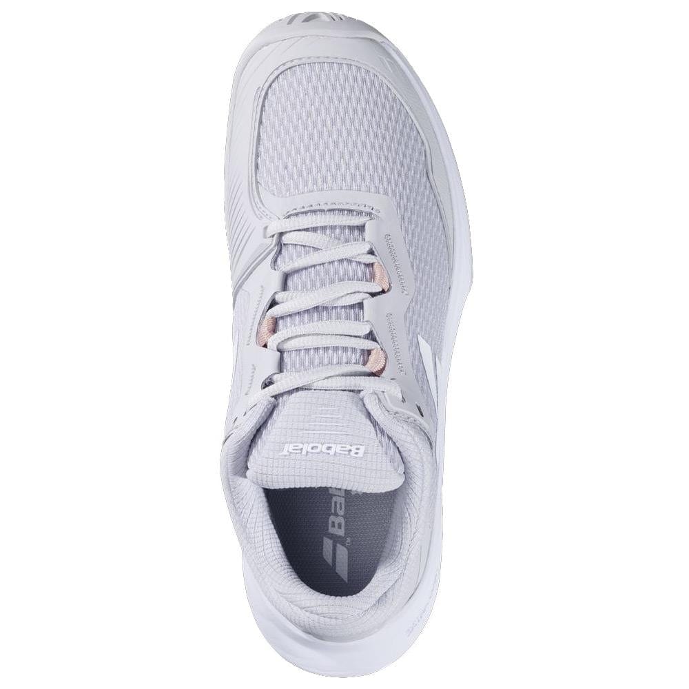 A top view of the Babolat SFX 4 All Court 2025 Women's Tennis Shoes in Lunar Rock shows a white mesh upper, sleek design, neatly tied laces, and a brand logo on the tongue. The outsole uses durable Michelin Original rubber for excellent performance on the court.