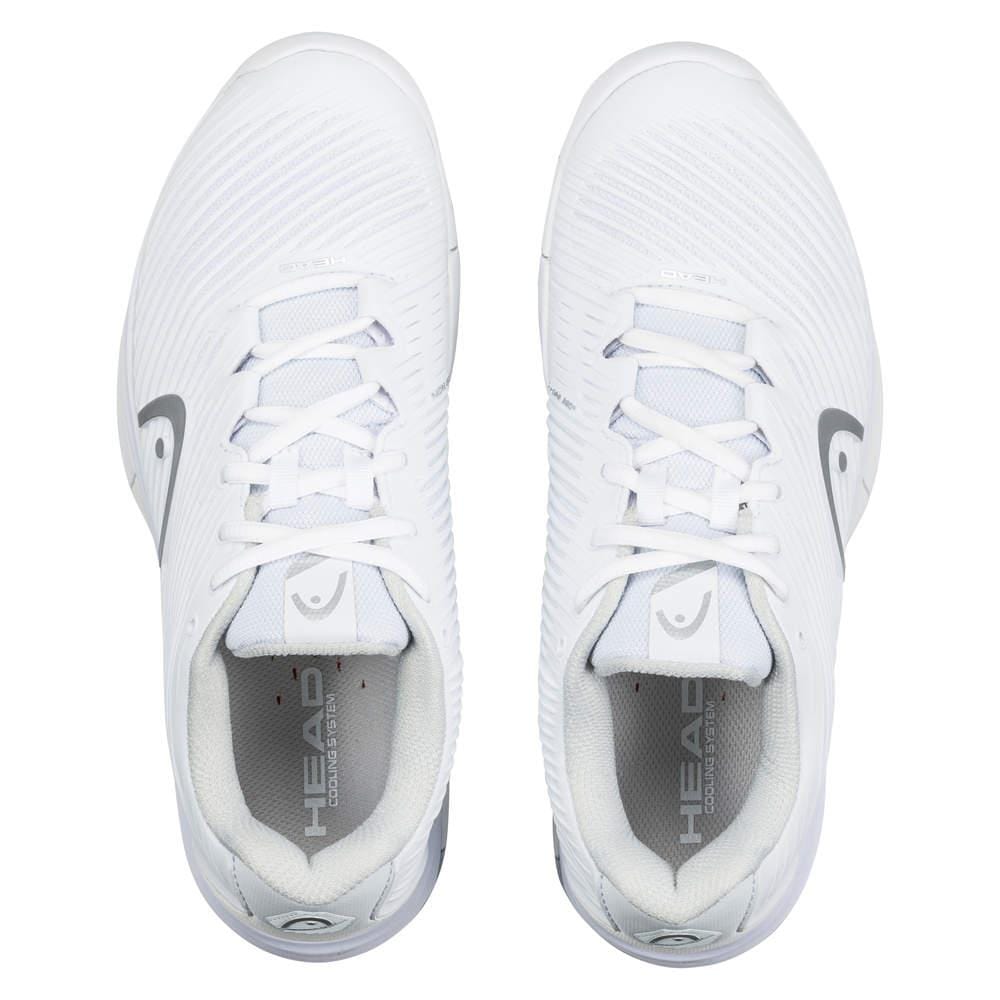 A top view of the HEAD Revolt Pro 4.0 Women's Tennis Shoes in white with grey details, featuring laces and the brand name "HEAD" on the inner soles. These shoes boast a sleek design and performance technologies to enhance abrasion resistance.