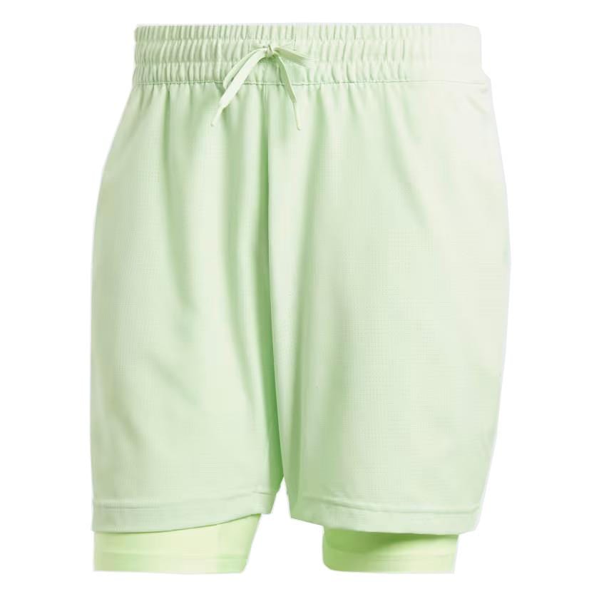 ADIDAS Melbourne Men's 2in1 Tennis Shorts feature a light green color and combine functionality with an elastic waistband and drawstring. Made from recycled materials, these adidas shorts showcase a unique layered design, with the longer inner layer extending slightly below the hem, providing optimal comfort and cooling during matches.