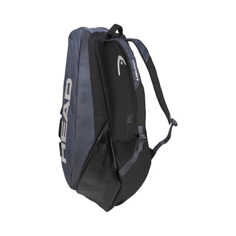 The HEAD Djokovic 9R Supercombi Tennis Bag in Black and Grey showcases the "HEAD" logo prominently on its side. Designed with multiple compartments and adjustable shoulder straps, this sleek bag is perfect for transporting sports equipment. It complements the SPEED racket series while providing advanced climate control technology to protect your gear.