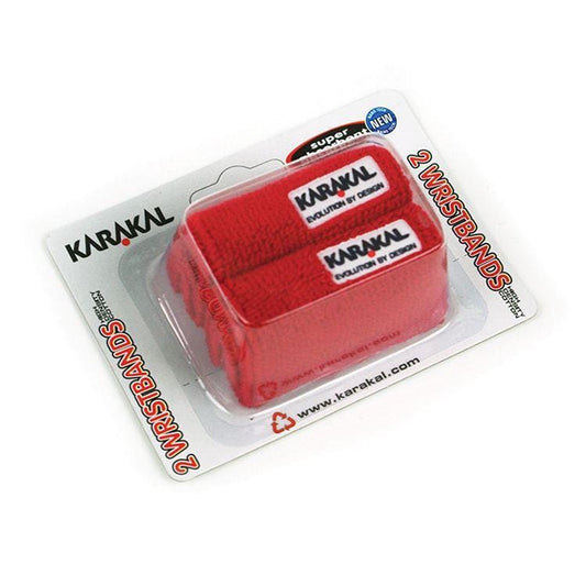 Twin pack of Karakal Tennis Wrist Bands in red, featuring super absorbent cotton material perfect for sports like tennis. The wristbands come in transparent packaging with visible branding labels, including the brand name, Karakal, and its website.