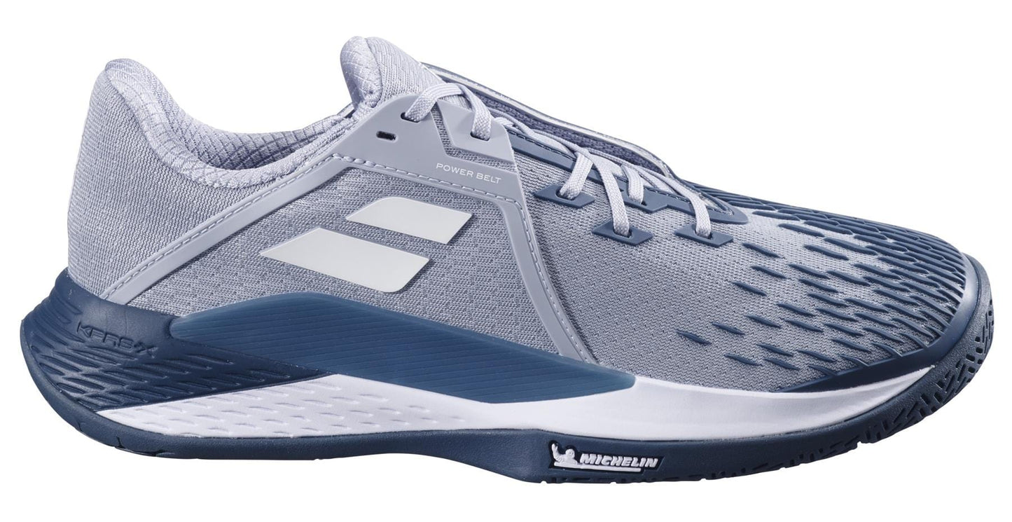 The Babolat Propulse Fury 3 All Court 2025 Mens Tennis Shoes in grey/white showcase premium technology with a textured toe design. Featuring a Michelin logo on the sole, they have two white geometric shapes on the upper, light gray lining, and lace-up closure.