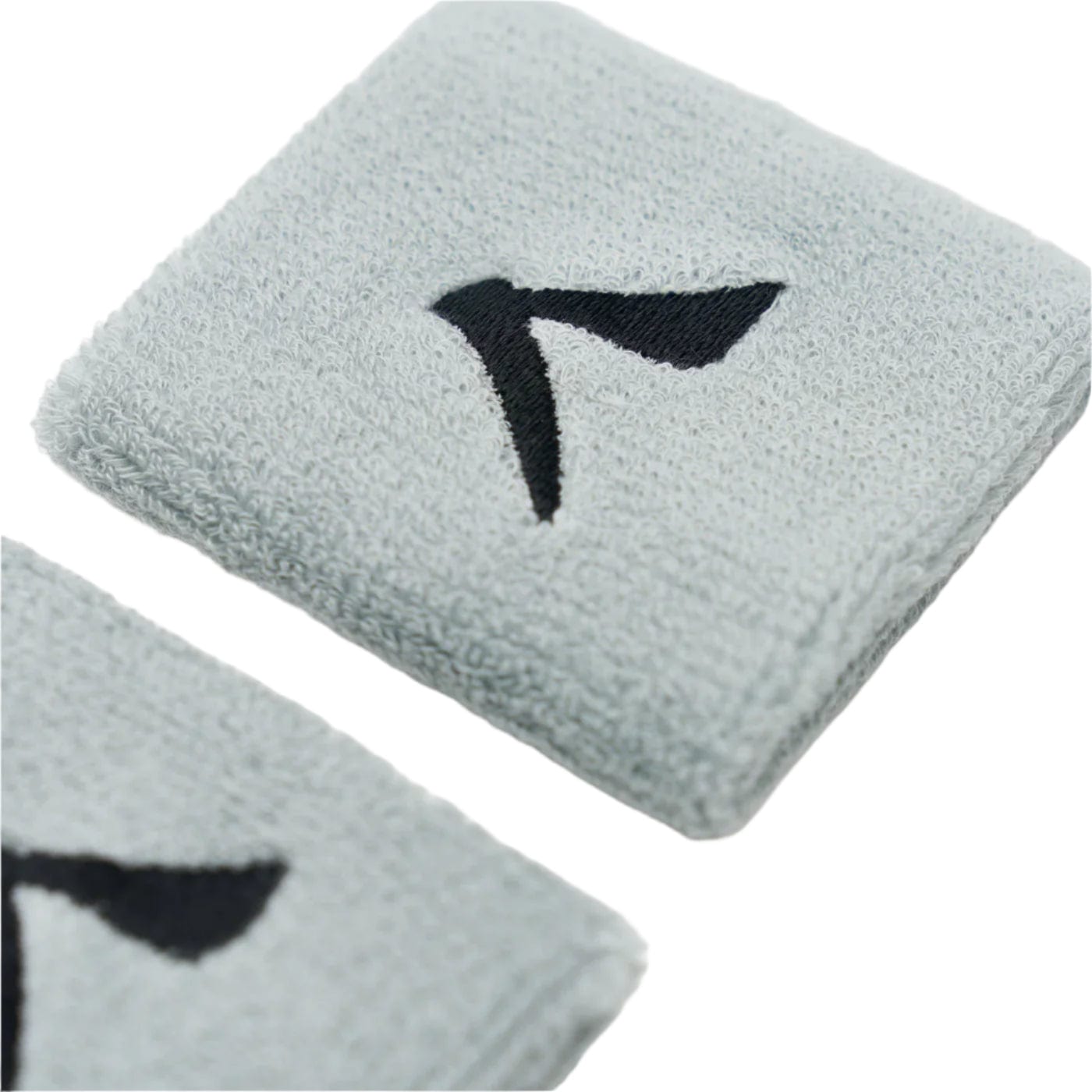 The Kanso 7cm Wristband - 2 Pack in grey, featuring a black abstract logo, offers maximum comfort with its soft, absorbent fabric. One is partially cropped at the bottom left, and they combine towel-like functionality with style effortlessly.