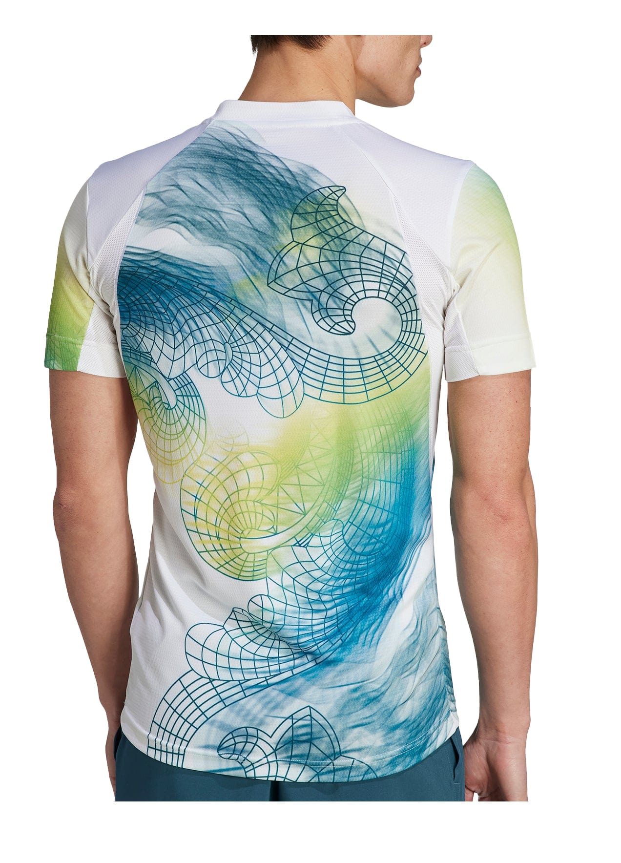 An individual wearing the adidas Mens Printed Aeroready Freelift Pro Tennis T-Shirt in White, made from recycled materials and displaying an abstract design of swirling blue and green patterns with grid lines on the back. The detailed artwork on the shirt highlights a dedication to sustainability, as the person turns away to exhibit it.