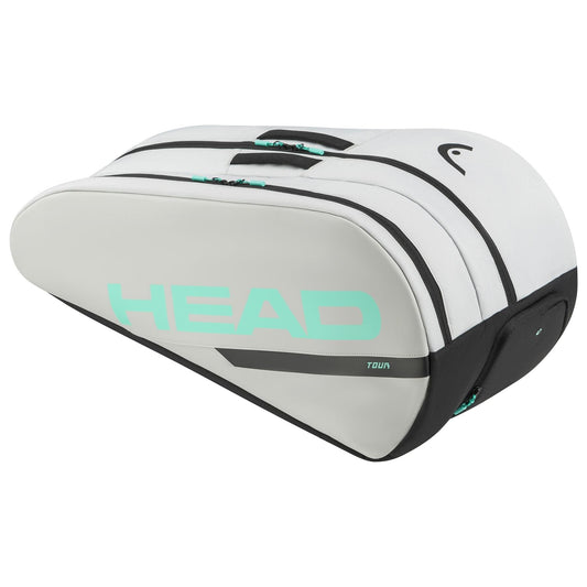 The HEAD Tour Tennis Racket Bag L - CCTE is elegantly designed in white and black, with the "HEAD" brand prominently displayed in large turquoise letters. It includes Climate Control Technology and features multiple compartments along with sturdy handles for comfortable carrying.