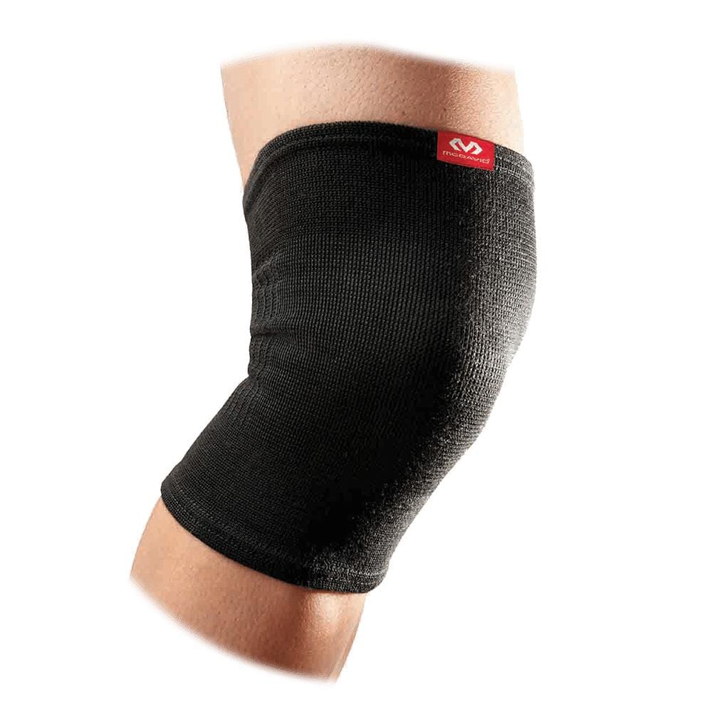 A close-up image shows a person's knee wearing the McDavid 2-Way Elastic Knee Sleeve, which features a black brace with a red logo on top. This breathable knee sleeve covers the knee and part of the thigh and calf, offering essential support and compression.