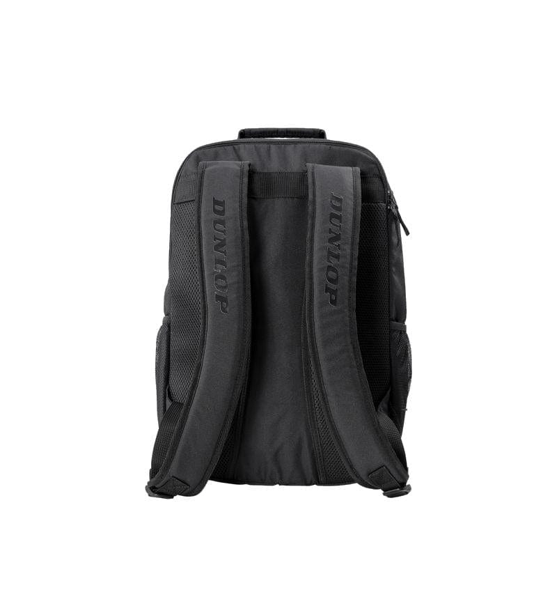 The Dunlop Team Tennis Backpack - Black is displayed from the rear, showcasing two brand-name-adorned padded shoulder straps. It offers side pockets, a top handle for easy transport, and dedicated compartments for racket protection.