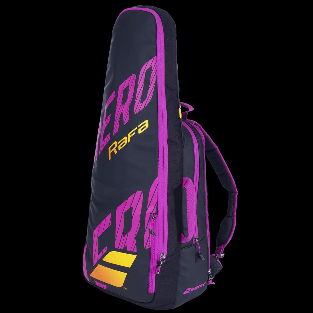 This Babolat Pure Aero RAFA Tennis Backpack in black, pink, and yellow features "Rafa" in yellow and "Aero" in pink. It offers multiple compartments and comes with convenient backpack-style straps.