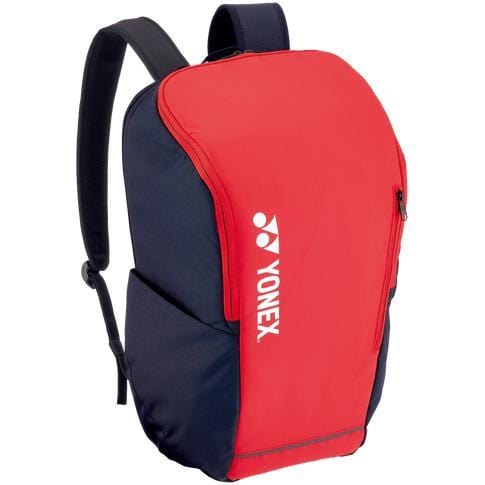 The Yonex 42312SEX Team Backpack in Scarlet showcases a sleek curved front design and a convenient side zip pocket. The white Yonex logo stands out prominently on the front. Perfect for racket sports, this backpack includes padded, adjustable black shoulder straps to ensure maximum comfort.