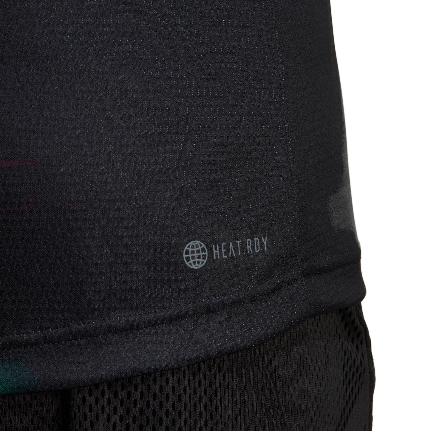 Close-up of a black sports fabric with mesh texture, showcasing a small globe icon and the text "HEAT.RDY" on the lower part. Drawing inspiration from the adidas Melbourne Men's Freelift Tennis Polo Shirt - Black / Multi, this design ensures comfort and performance. The dark background accentuates its sleekness.