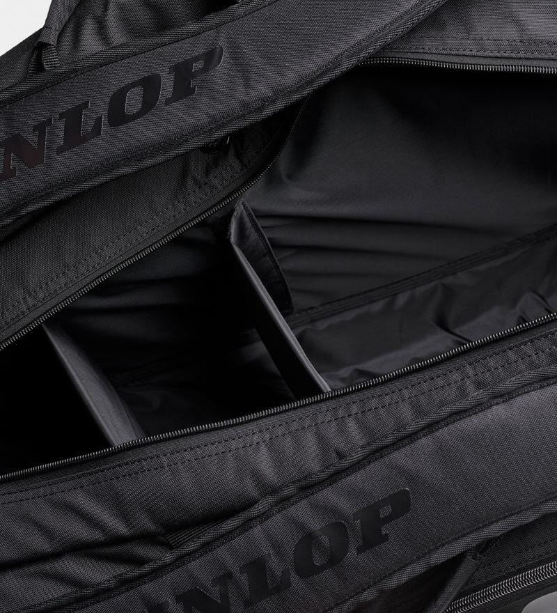 The Dunlop Team 12 Racket Thermo Tennis Bag - Black, with its open design revealing spacious compartments, highlights its interior capacity. Crafted from durable fabric and equipped with zippers, the bag also displays the Dunlop brand logo on its straps. Additionally, it features thermo insulation to maintain your gear in peak condition.