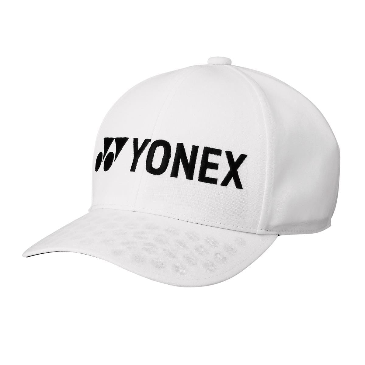 The Yonex 40063 Tennis Cap in white is a baseball cap that prominently displays the bold black Yonex logo and name on the front. Made from sweat-wicking material, it features a curved brim with a pattern of small circles on the underside, offering both style and comfort for every match.