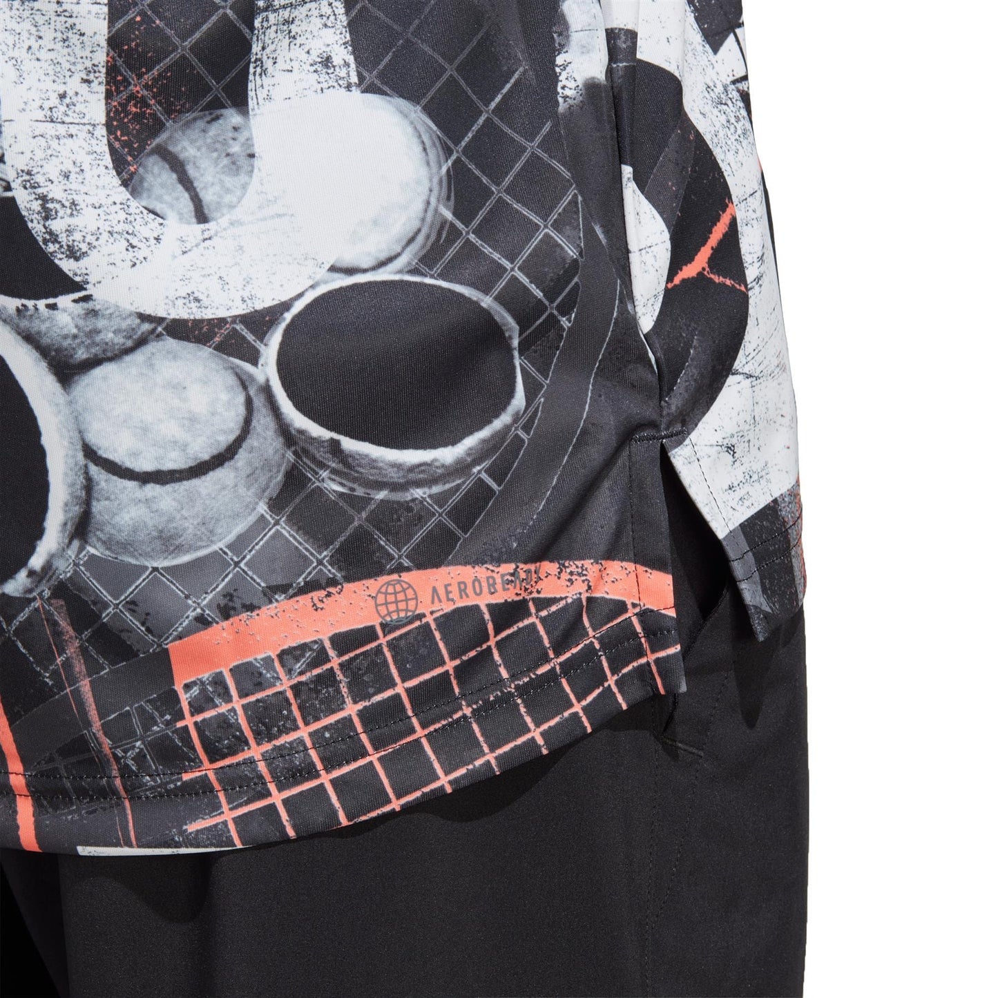 Close-up of the adidas Club Men's Graphic Tennis T-Shirt in white and black, showcasing tennis balls and rackets against a striking background. The design features dynamic abstract patterns with textured details and red accents. Made from recycled polyester, it boasts an "AEROREADY" label for moisture-wicking comfort provided by adidas.