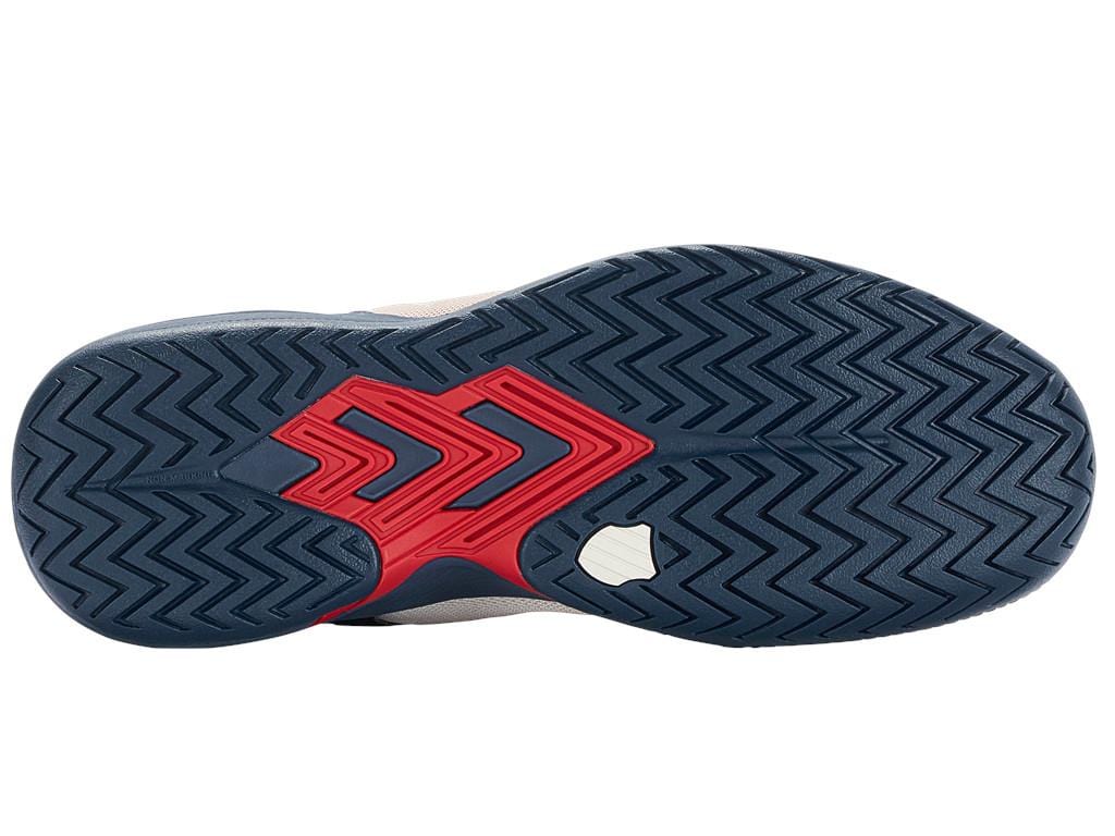 The image displays the sole of the K-Swiss Ultrashot Team Men's Tennis Shoe, showcasing a blue herringbone tread pattern with red accents in the center. This design is perfect for performance tennis shoes, and there is a small white section near the heel.