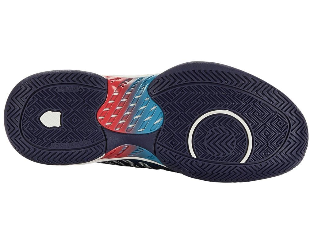 The image features the sole of a K-Swiss Hypercourt Supreme men's tennis shoe in Blue Opal, White, and Lollipop colors. It displays intricate tread patterns with circular and zigzag motifs for improved grip and traction, enhanced by DragGuard 7.0 technology for added durability.
