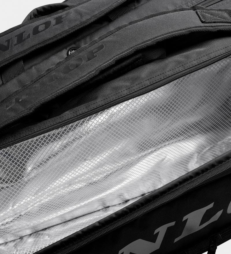 A partially unzipped Dunlop Team 12 Racket Thermo Tennis Bag in black reveals a reflective silver interior with thermo insulation. The open bag showcases its textured lining and sturdy handles, with the Dunlop brand name visible on the exterior.
