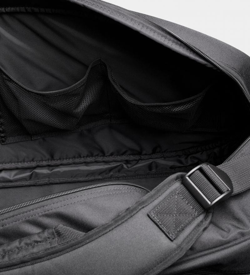 Close-up of an open Dunlop Team 8 Racket Thermo Tennis Bag - Black, showcasing its spacious interior. The bag includes multiple mesh pockets for organization, a padded strap with an adjustable buckle, and advanced temperature regulation features akin to a Racket Thermo Tennis bag, emphasizing its practical design for carrying essentials.